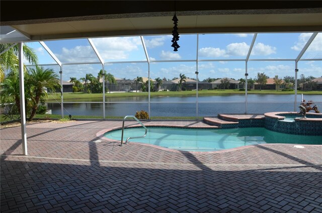 view of swimming pool with a patio area, glass enclosure, a water view, and an in ground hot tub