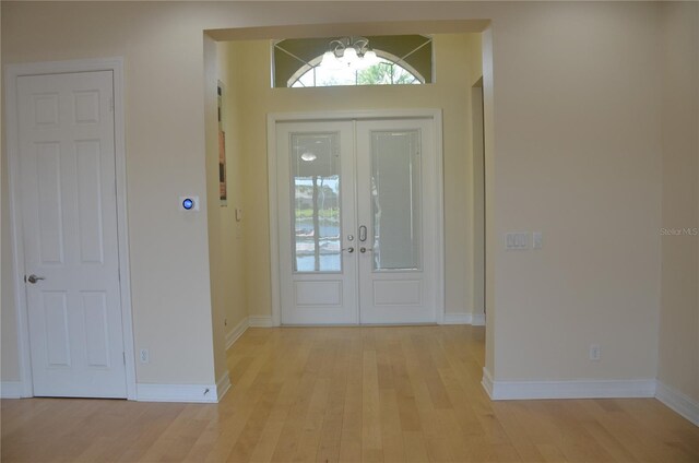 foyer entrance with light wood-type flooring and french doors