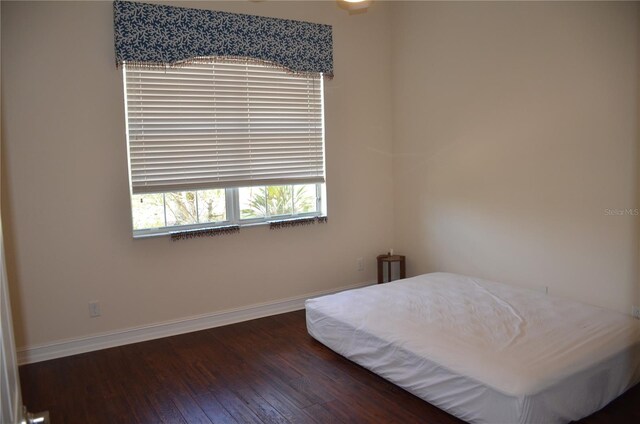 bedroom with dark hardwood / wood-style flooring