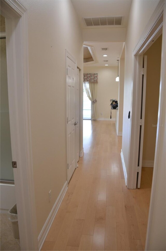 corridor with light hardwood / wood-style flooring