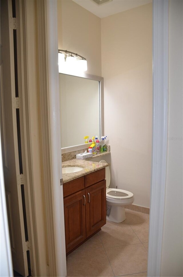 bathroom featuring tile patterned flooring, vanity, and toilet