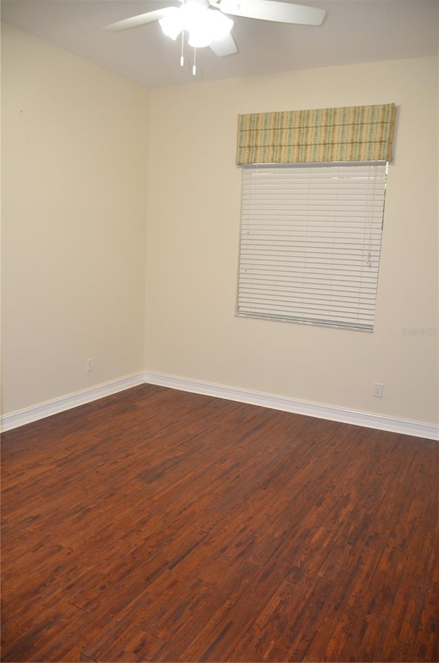 empty room featuring dark wood-type flooring and ceiling fan