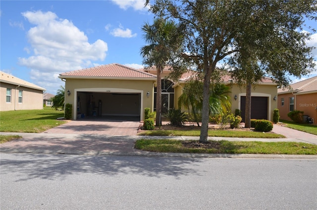 mediterranean / spanish-style home featuring a garage and a front yard