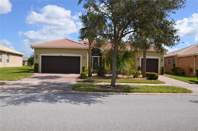 mediterranean / spanish-style house with a garage and a front yard