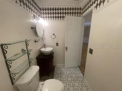 bathroom featuring vanity, toilet, and crown molding