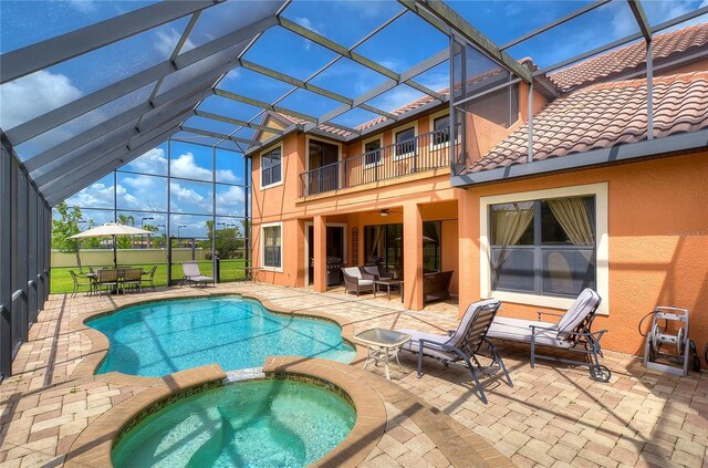 view of pool featuring an outdoor living space, glass enclosure, an in ground hot tub, and a patio