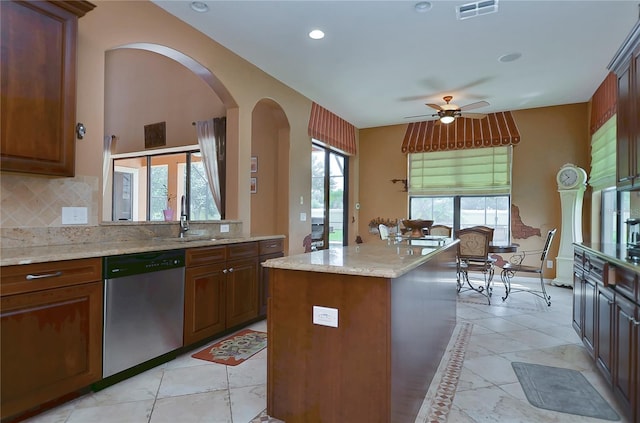 kitchen with backsplash, a wealth of natural light, a center island, and stainless steel dishwasher