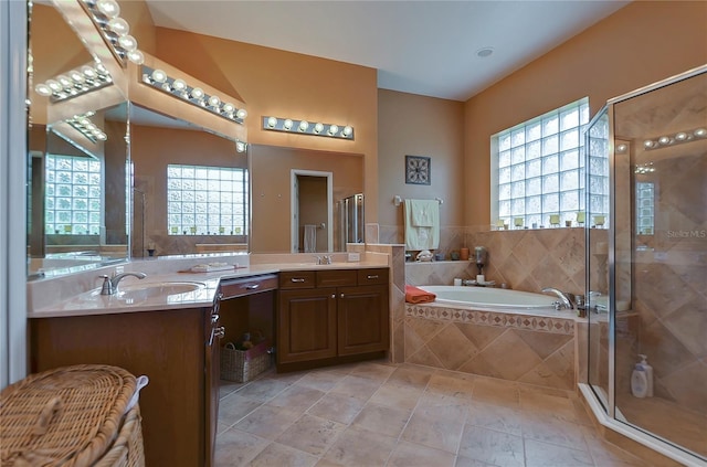 bathroom with vanity, separate shower and tub, and a wealth of natural light