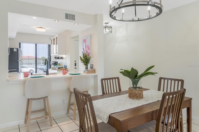 tiled dining space with a chandelier and sink