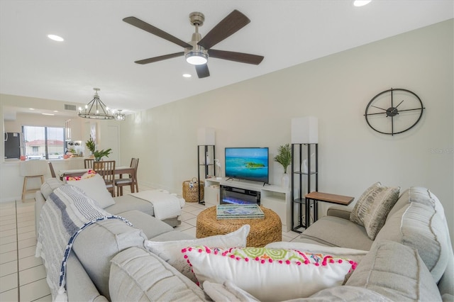 living room with light tile patterned floors and ceiling fan with notable chandelier