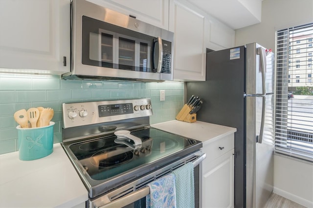 kitchen with white cabinets, decorative backsplash, and appliances with stainless steel finishes