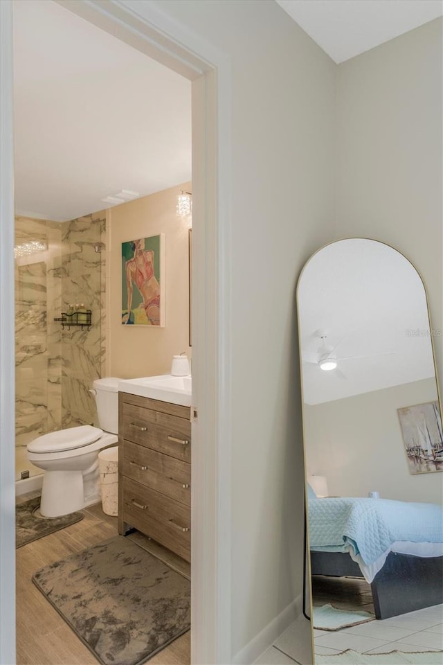 bathroom featuring hardwood / wood-style floors, vanity, toilet, and walk in shower