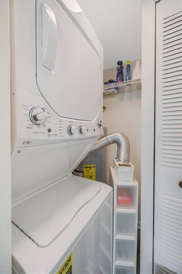 laundry room with a textured ceiling and stacked washer and clothes dryer