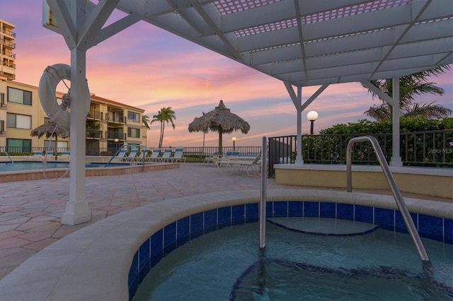 pool at dusk with a patio