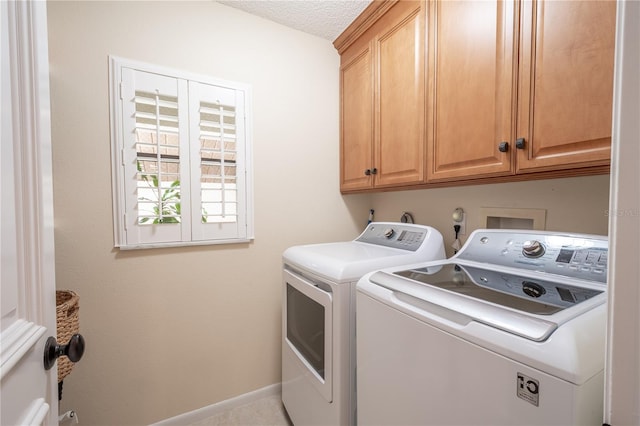 washroom featuring cabinets, washer and dryer, and a textured ceiling