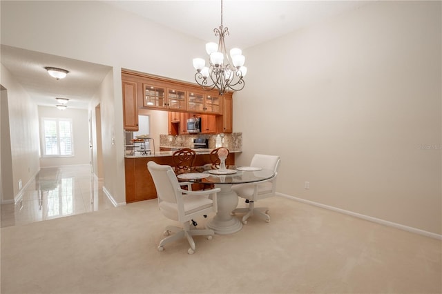 dining area with light carpet and a notable chandelier