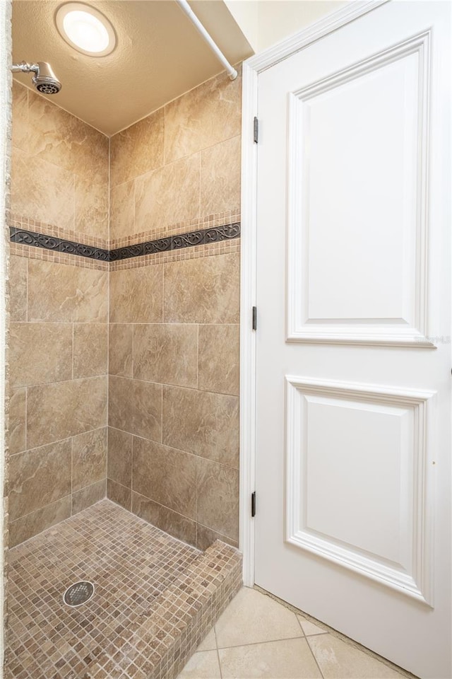 bathroom with tile patterned flooring and tiled shower