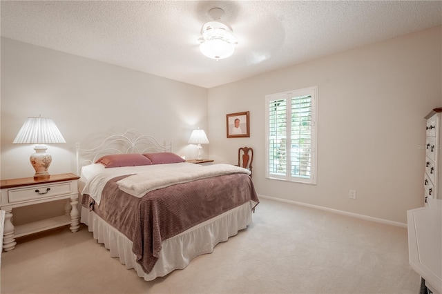 bedroom with light colored carpet and a textured ceiling