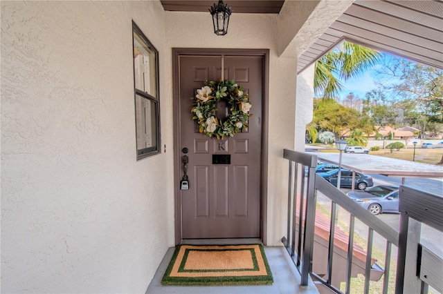 entrance to property with a balcony and stucco siding