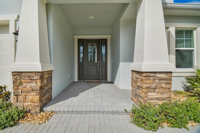 property entrance with stone siding and stucco siding