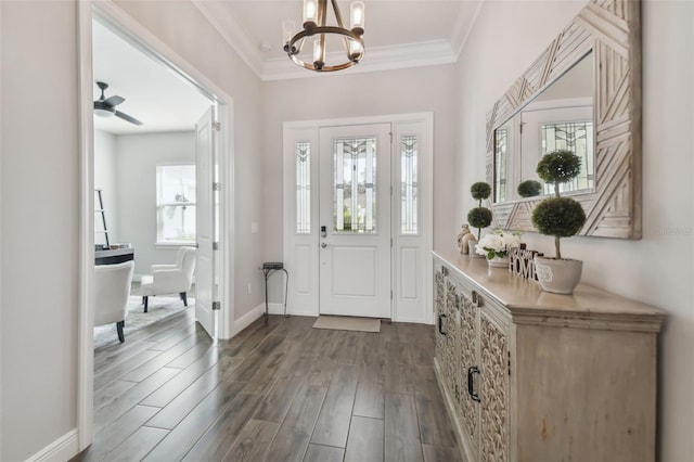 entryway featuring ornamental molding, ceiling fan with notable chandelier, baseboards, and wood finished floors