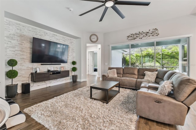 living area with dark wood-style flooring, ceiling fan, and baseboards