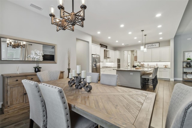 dining area featuring a chandelier, light wood-type flooring, visible vents, and recessed lighting