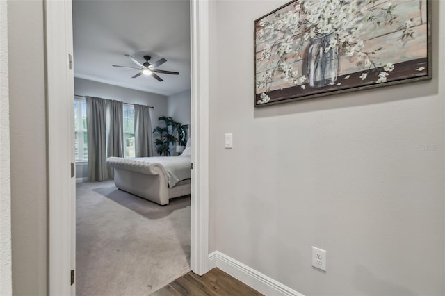 bedroom with carpet floors, ceiling fan, baseboards, and wood finished floors