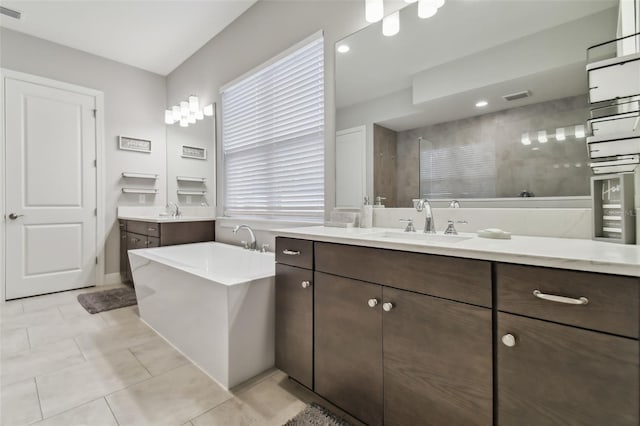 full bath featuring two vanities, visible vents, a sink, and a walk in shower