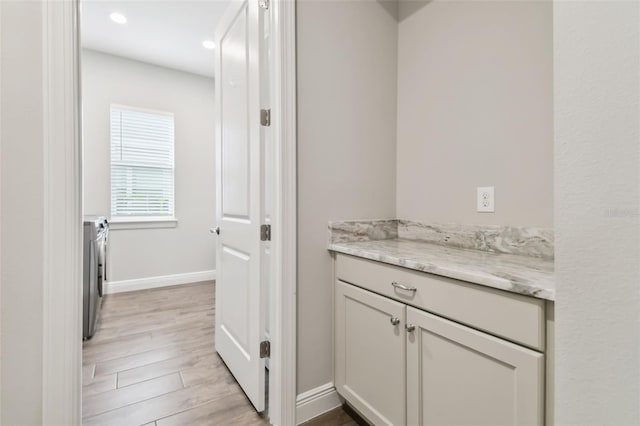 bathroom featuring recessed lighting, separate washer and dryer, wood finished floors, vanity, and baseboards