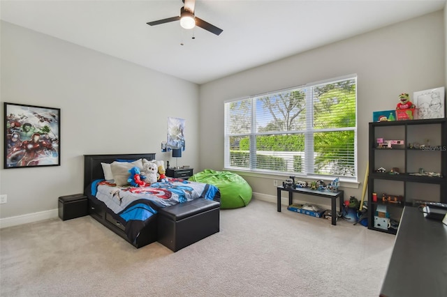 bedroom with a ceiling fan, light carpet, and baseboards