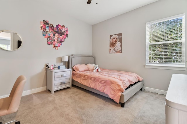 bedroom with light carpet, baseboards, and a ceiling fan