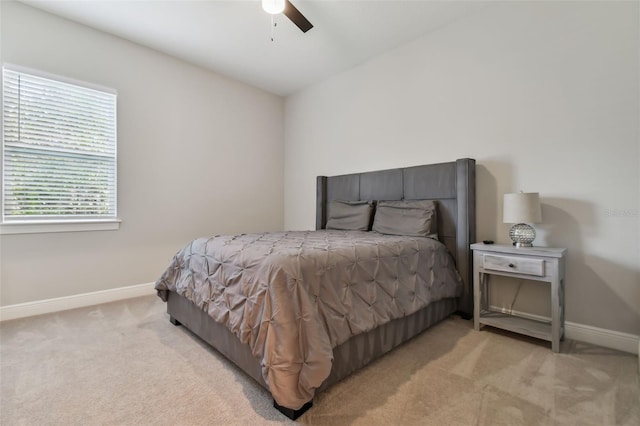 bedroom featuring a ceiling fan, light carpet, and baseboards