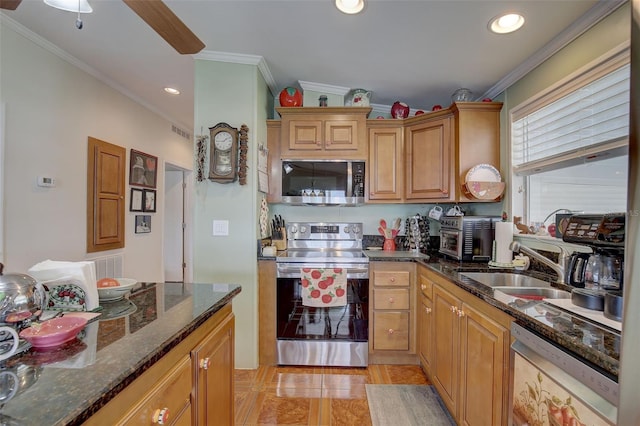 kitchen with ornamental molding, sink, stainless steel appliances, and dark stone countertops