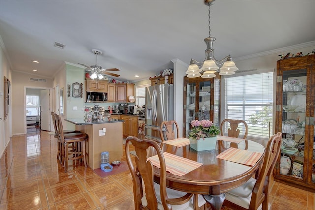 tiled dining area featuring a healthy amount of sunlight, ornamental molding, and ceiling fan with notable chandelier