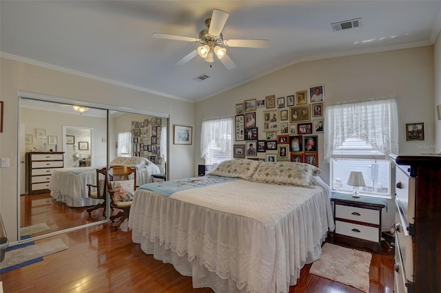 bedroom with a closet, multiple windows, hardwood / wood-style flooring, and ceiling fan