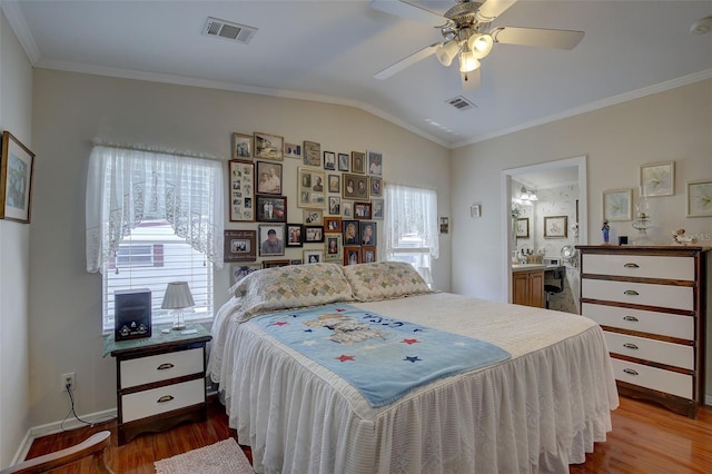 bedroom with ceiling fan, multiple windows, light wood-type flooring, and ensuite bathroom