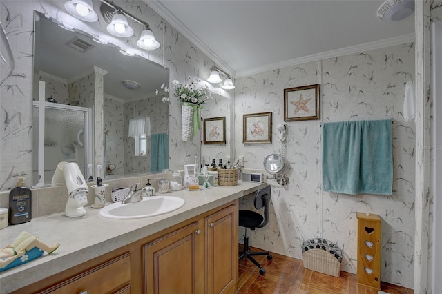 bathroom with vanity, crown molding, and a shower with door