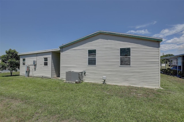 view of home's exterior with cooling unit and a yard