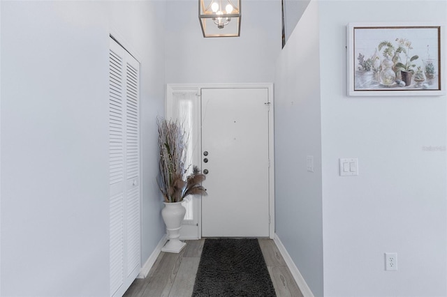 doorway with hardwood / wood-style flooring and an inviting chandelier