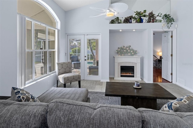 living room with french doors, vaulted ceiling, light wood-type flooring, and ceiling fan