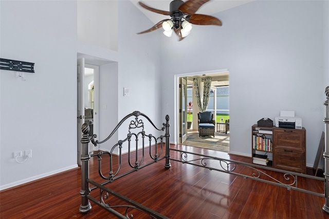 bedroom with a high ceiling, hardwood / wood-style flooring, and ceiling fan