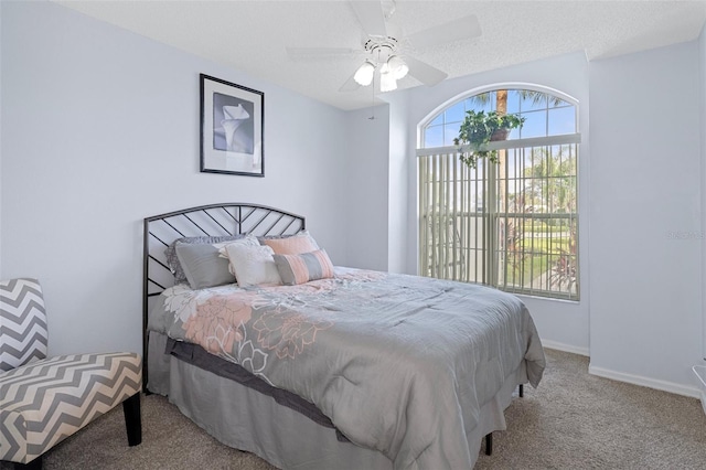 carpeted bedroom with a textured ceiling and ceiling fan