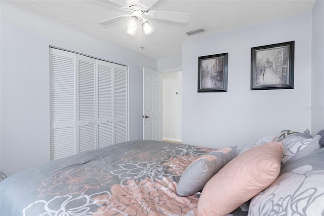 bedroom featuring a closet, a textured ceiling, and ceiling fan