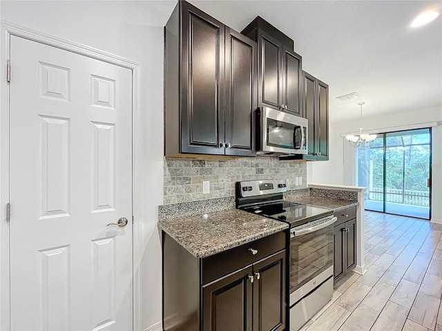 kitchen with dark brown cabinets, hanging light fixtures, appliances with stainless steel finishes, a chandelier, and stone countertops