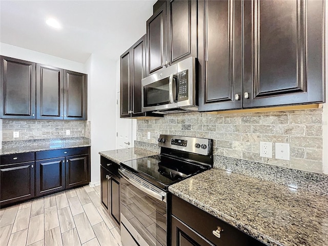 kitchen with light stone counters, stainless steel appliances, decorative backsplash, and dark brown cabinetry