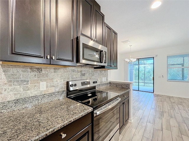 kitchen with stainless steel appliances, dark brown cabinets, and hanging light fixtures