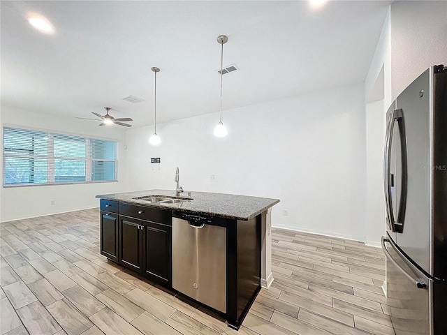 kitchen featuring ceiling fan, a kitchen island with sink, light wood-type flooring, sink, and stainless steel appliances