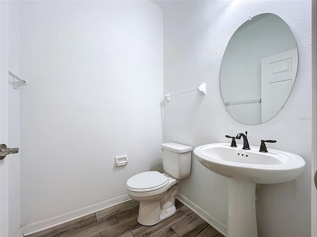 bathroom with toilet and hardwood / wood-style floors