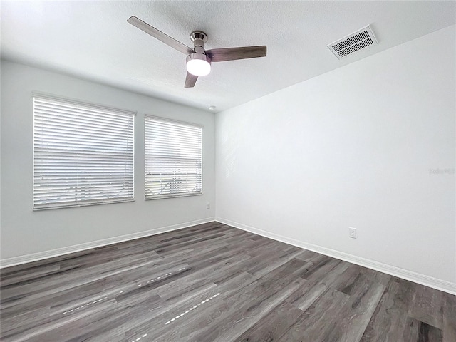 empty room with dark wood-type flooring, ceiling fan, and a textured ceiling